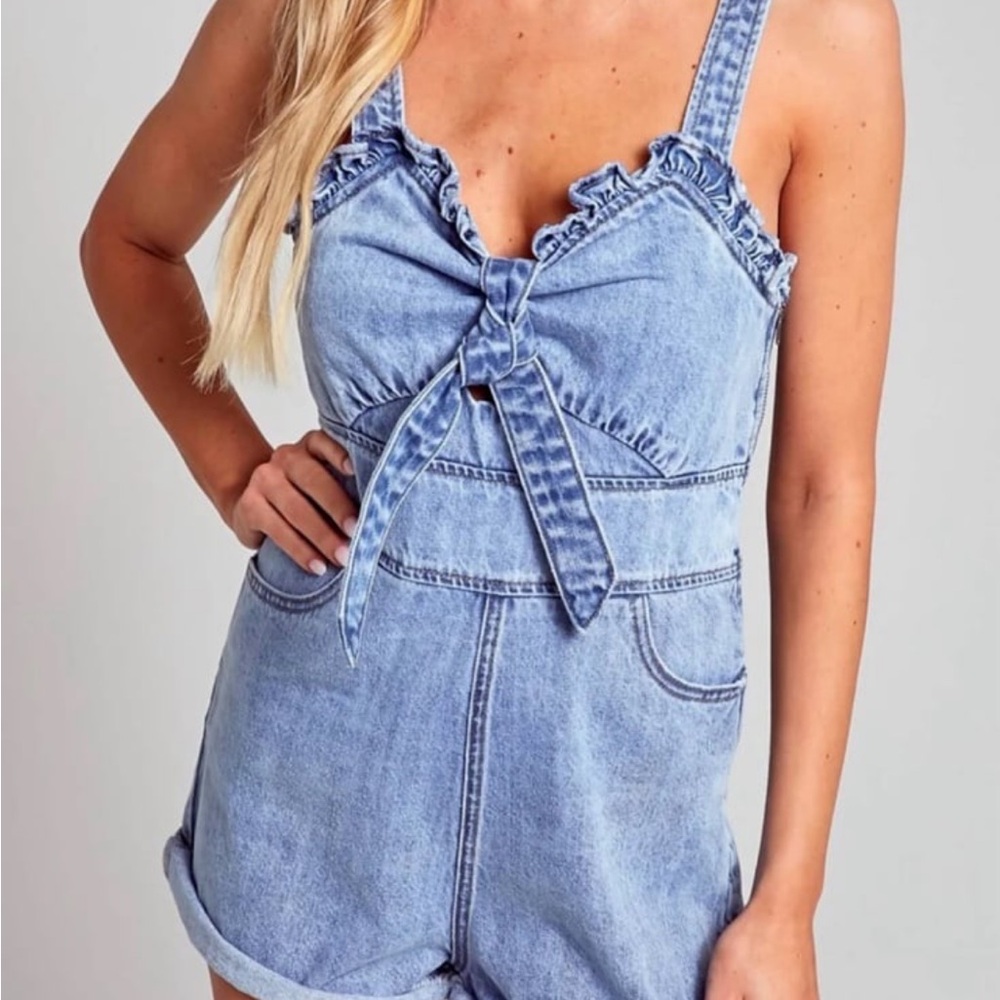 Blue Blush denim romper with a front bow tie,‎ ruffle trim, and pockets size L